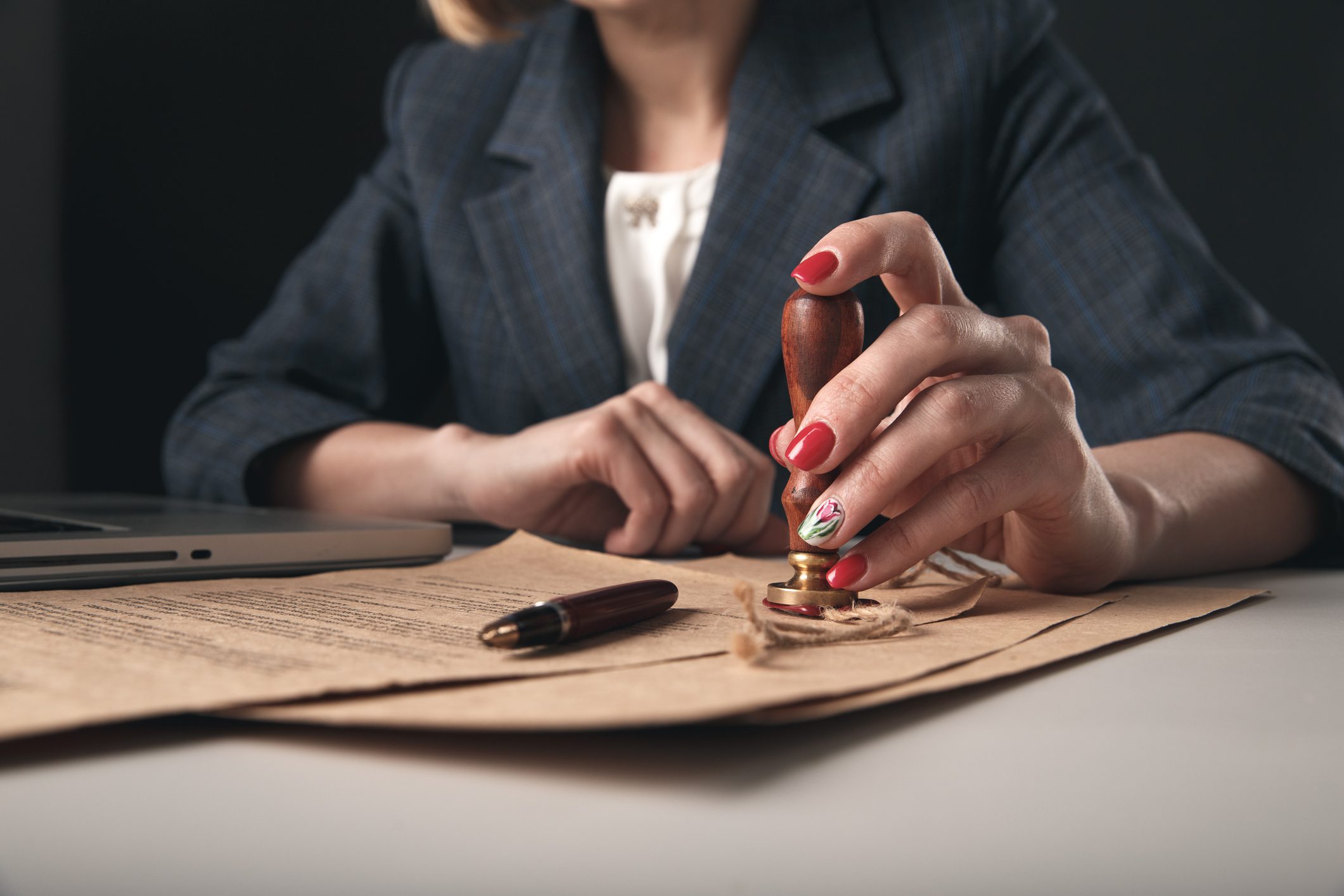 Closeup view of woman attorney writing on documents by pen